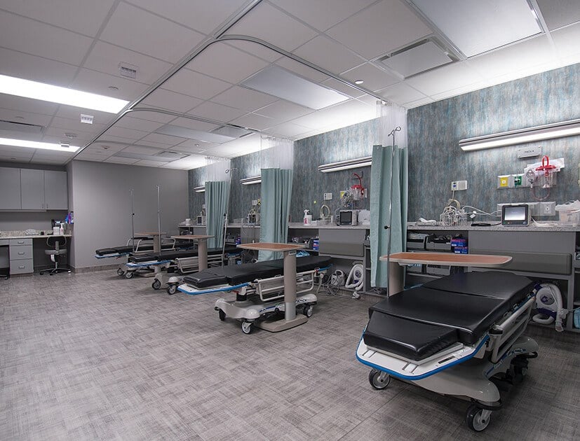 A modern surgical room featuring an operating table, surgical lights, and various medical equipment.