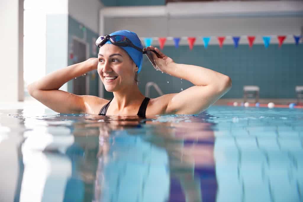 oman enjoying swimming pool after successful breast augmentation recovery, demonstrating safe return to water activities following proper healing timeline