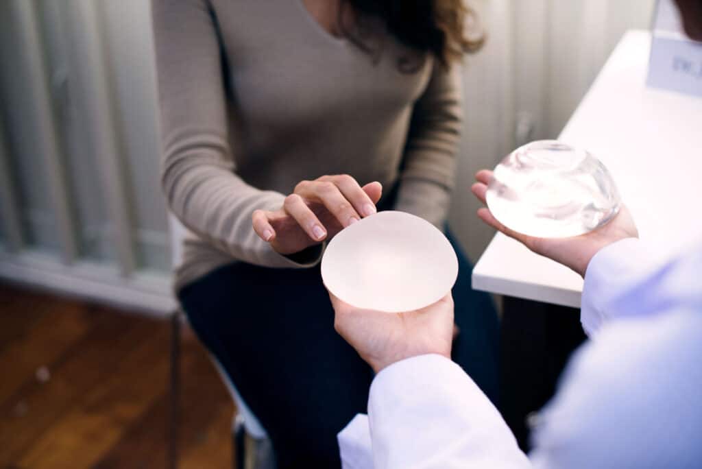 Woman comparing the best types of breast implants with a surgeon during consultation.