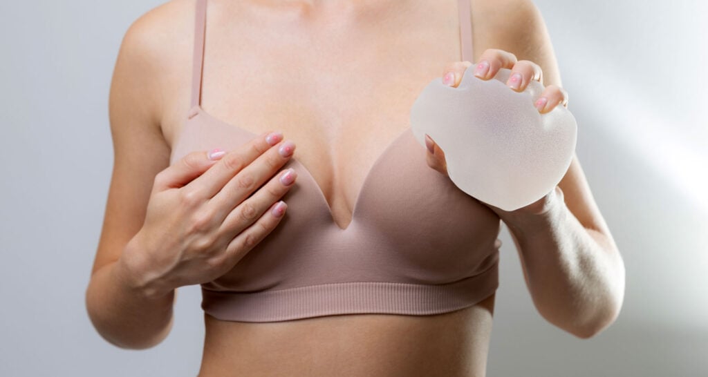 Woman gently squeezing Motiva implant sample to evaluate safety and durability.